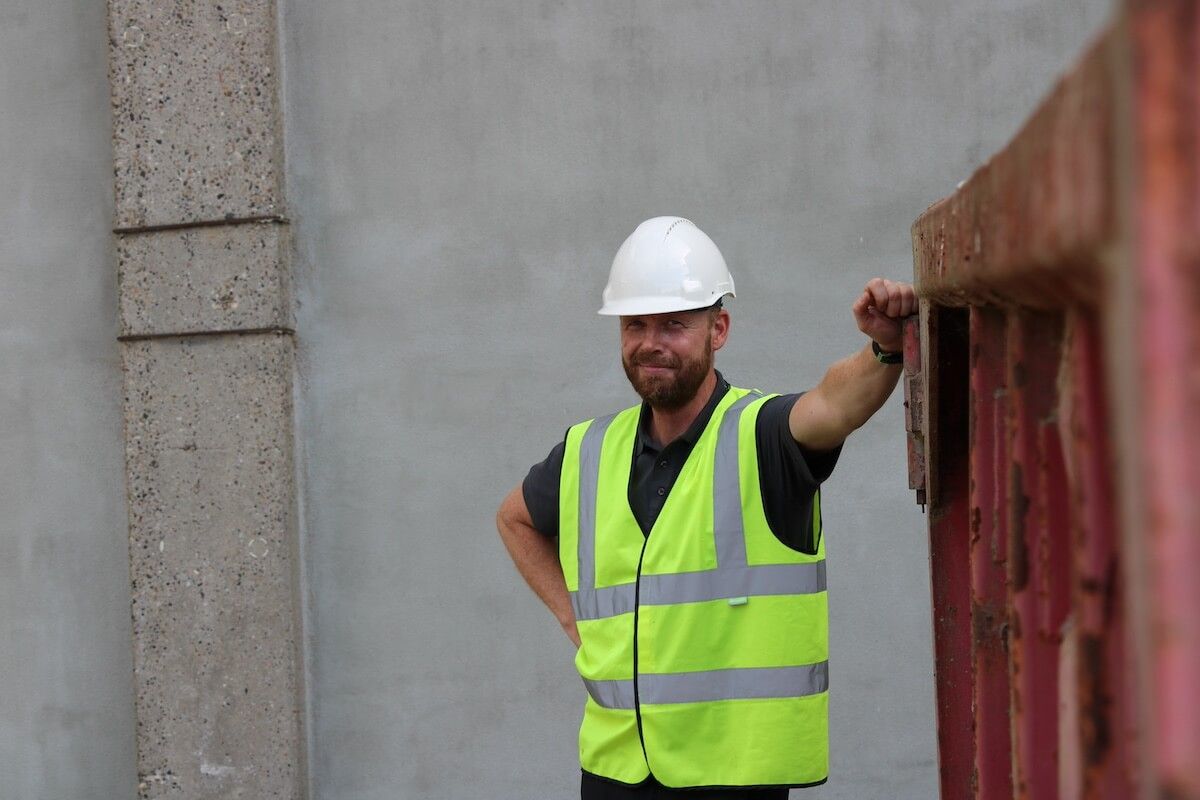 Findan mand står i gul vest og hvid hjelm