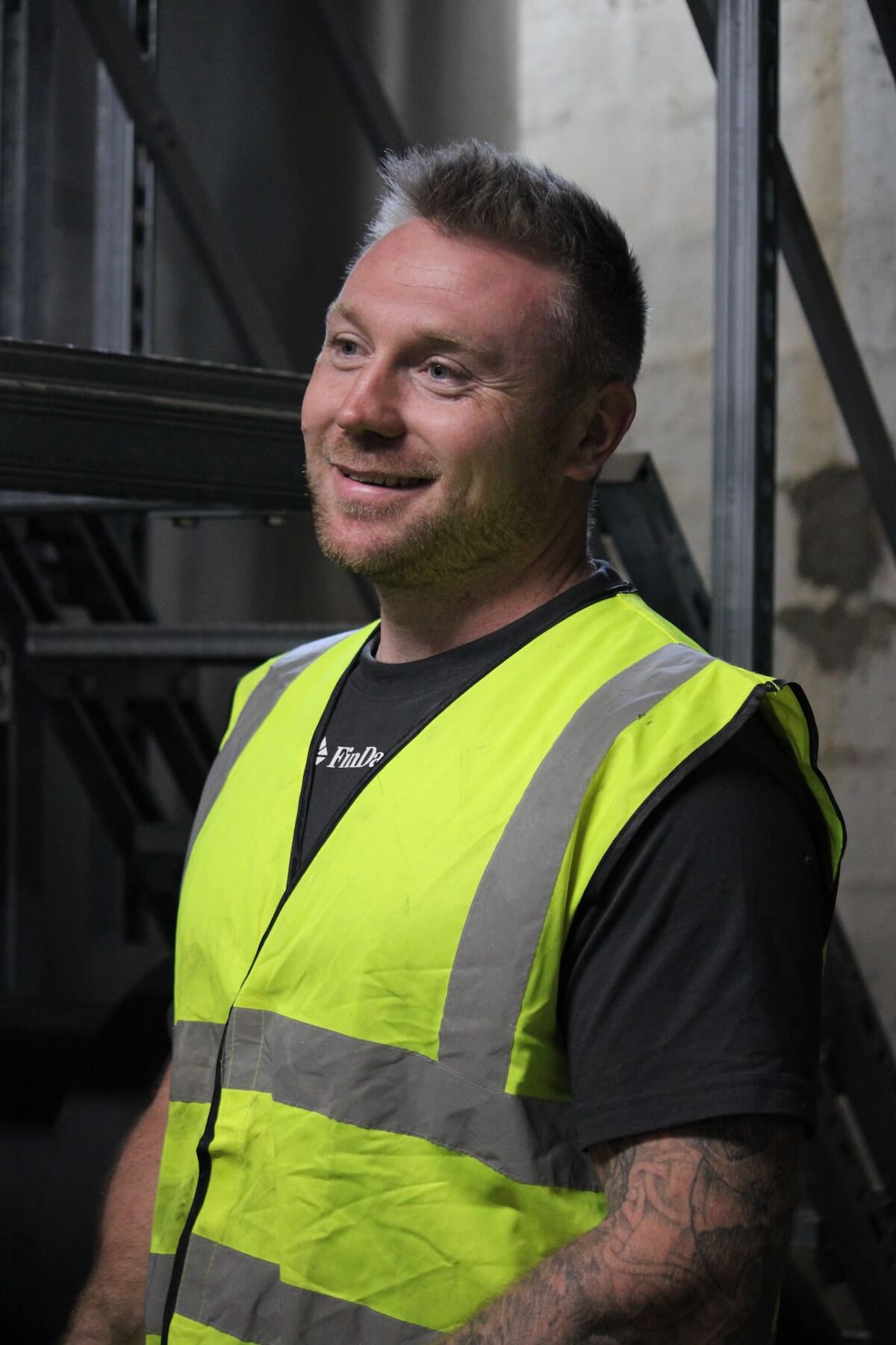 Findan mand i gul vest smiler
